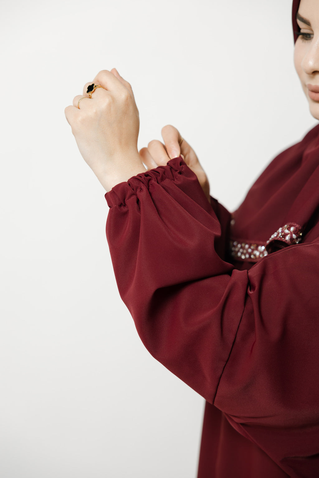 Maroon long-sleeve garment with ruffled cuffs on a white background